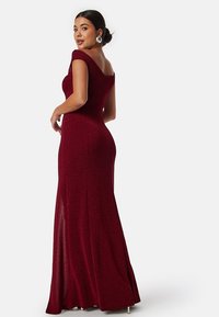 Bordeaux aftonklänning med off-the-shoulder-design, figursydd liv och golvlång kjol med sidofålla och texturerad väv.