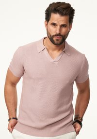 Hellrosa Kurzarm-Polohemd aus Strick mit V-Ausschnitt und geripptem Kragen. Strukturierte Textur mit taillierter Silhouette.