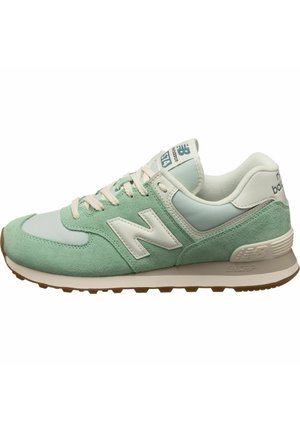 Low-top New Balance sneaker i mintgrøn og hvid med beige snørebånd, polstret sål og logo på siden og tungen.