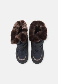 Botas de invierno de la marina con puños de piel sintética marrón, dos correas de Velcro negras, material sintético suave y suelas texturizadas para un buen agarre.