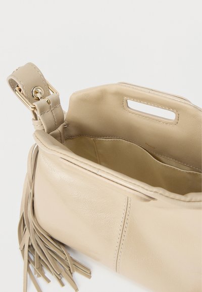 Μπεζ δερμάτινη τσάντα με υφή, ανοιχτό πάνω μέρος και εσωτερική τσέπη. Διαθέτει διακόσμηση με φούντες και κοντή λαβή.