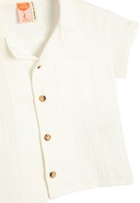 Hvid kortærmet skjorte med knaplukning, lavet af tekstureret stof, med en lomme, brune knapper og et afslappet kravedesign.
