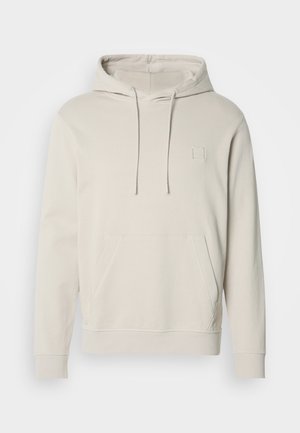 Svetlo béžová mikina s kapucňou, vyrobená z jemného materiálu, s prednou kapsou, šnúrkami na stiahnutie a malým štvorcovým logom na hrudi. Dlhé rukávy a rebrované manžety.