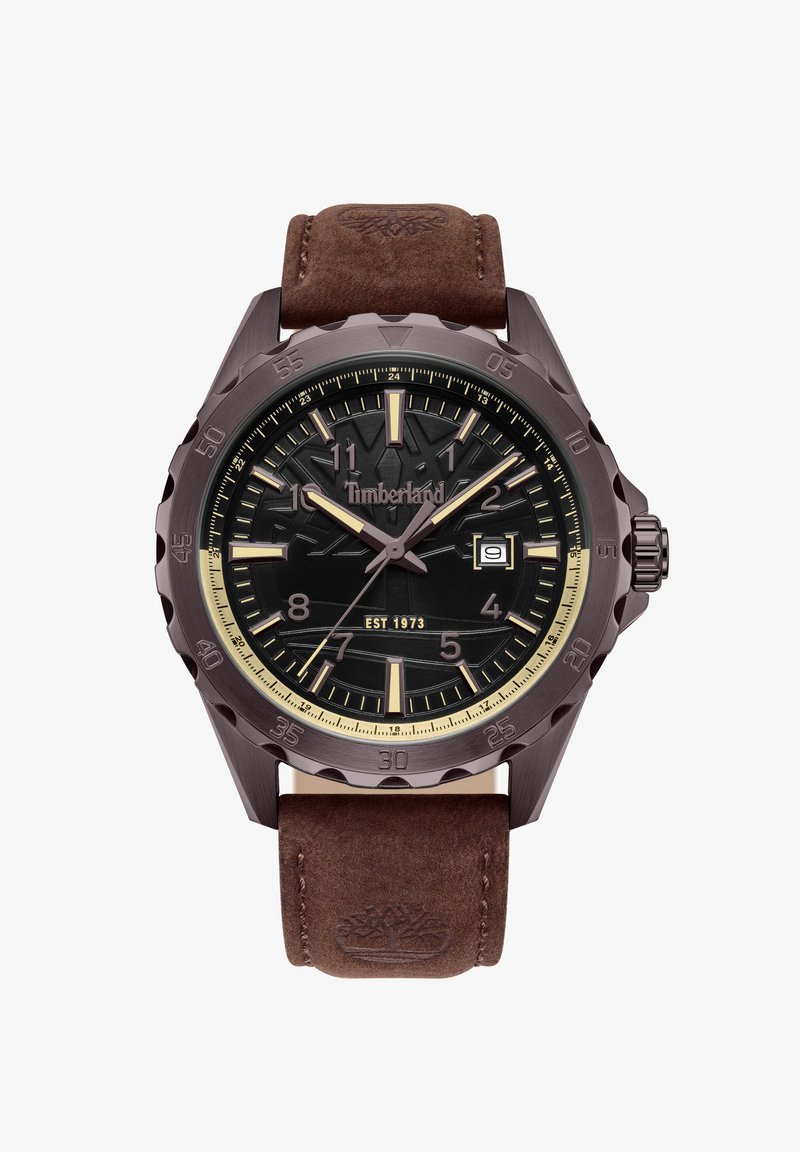Reloj Timberland con un dial redondo texturizado negro, acentos dorados y una pantalla de fecha. Correa de cuero marrón con logo grabado. Caja de metal duradera.