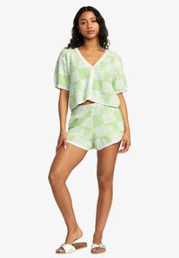 Grön och vit rutig stickad tvådelad set med en kortärmad cropped topp med v-ringning och matchande shorts.