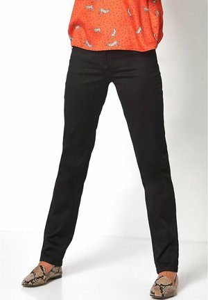 Pantaloni neri a gamba dritta realizzati in tessuto misto cotone. Presentano cuciture minime, tasche e sono abbinati a scarpe con stampa animale.