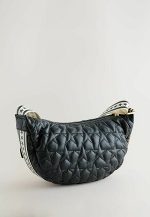 Czarna pikowana torebka o zaokrąglonym kształcie, zamykana na zamek, z ozdobnym paskiem z tkaniny w gwiazdy na krawędziach.