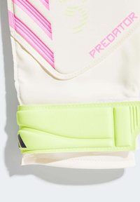 Guanti da portiere in bianco sporco, con audaci strisce rosa e dettagli verdi. Materiale testurizzato con cinturino in Velcro per una vestibilità sicura.