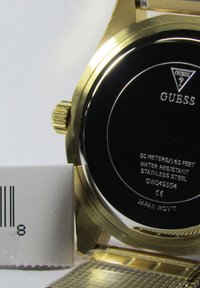 Goldfarbene Edelstahl-Uhr mit schwarzem Gehäuse und gravierten Details. Verfügt über ein strukturiertes Metallarmband. Wasserdicht bis 50 Meter.