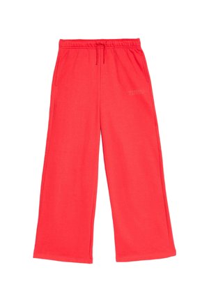 Pantalons de survêtement rouges à jambes larges, fabriqués en tissu doux, avec une taille élastique et un cordon de serrage. Présente un texte imprimé sur le côté.