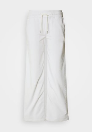 Bela široke hlače iz mehkega bombaža. Imajo elastičen pas z vrvico za zategovanje in subtilne detajle na stranskih šivih.