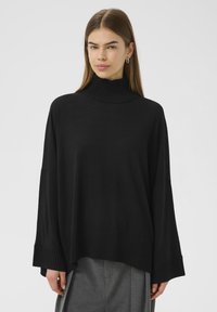 Črni, oversized pulover s turtleneck ovratnikom, z ribano teksturo in širokimi rokavi, ki ima subtilno lahkotno pletenje in sproščen silhueto.