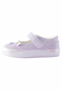 Chaussure de style Mary Jane violette avec une finition brillante, intérieur blanc, une sangle ajustable et des pompons décoratifs sur le bout. Semelle blanche.