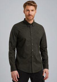 Mørkegrøn skjorte med knap-down lukning, tekstureret stof, lange ærmer og klassisk krave. Har frontknapper og en slim fit-design.