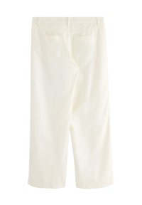 Bílé, kalhoty ke kolenům s hladkým povrchem, které mají dvě zadní kapsy a prošité detaily podél pásu a nohavic.