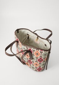 Woven textile tote bag with multicolored geometric pattern, brown leather accents, and striped lined interior featuring a zip pocket.