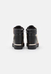 Černé vysoké tenisky s texturovaným designem, vybavené zlatým detailem na patě a zipem po stranách.