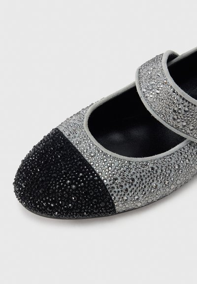 Grå och svart Mary Jane-sko med rund tå, täckt av strukturerade strassstenar och pärlor. Har en silverrem över vristen.