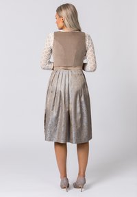 Tan velvet bodice with textured cream lace sleeves, paired with a pleated silvery-brown skirt featuring a floral pattern. Grey heels.