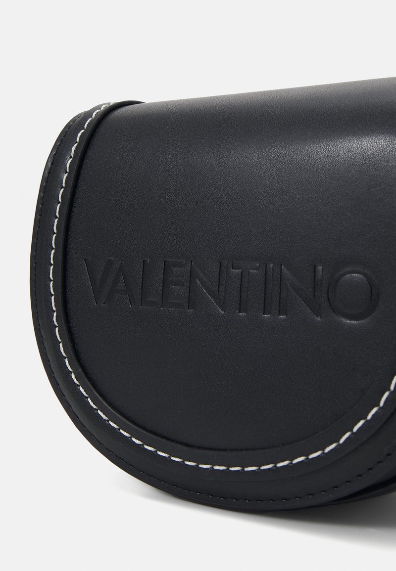 Borsa in pelle nera con marchio in rilievo, caratterizzata da cuciture bianche a contrasto lungo il bordo e da una forma arrotondata.