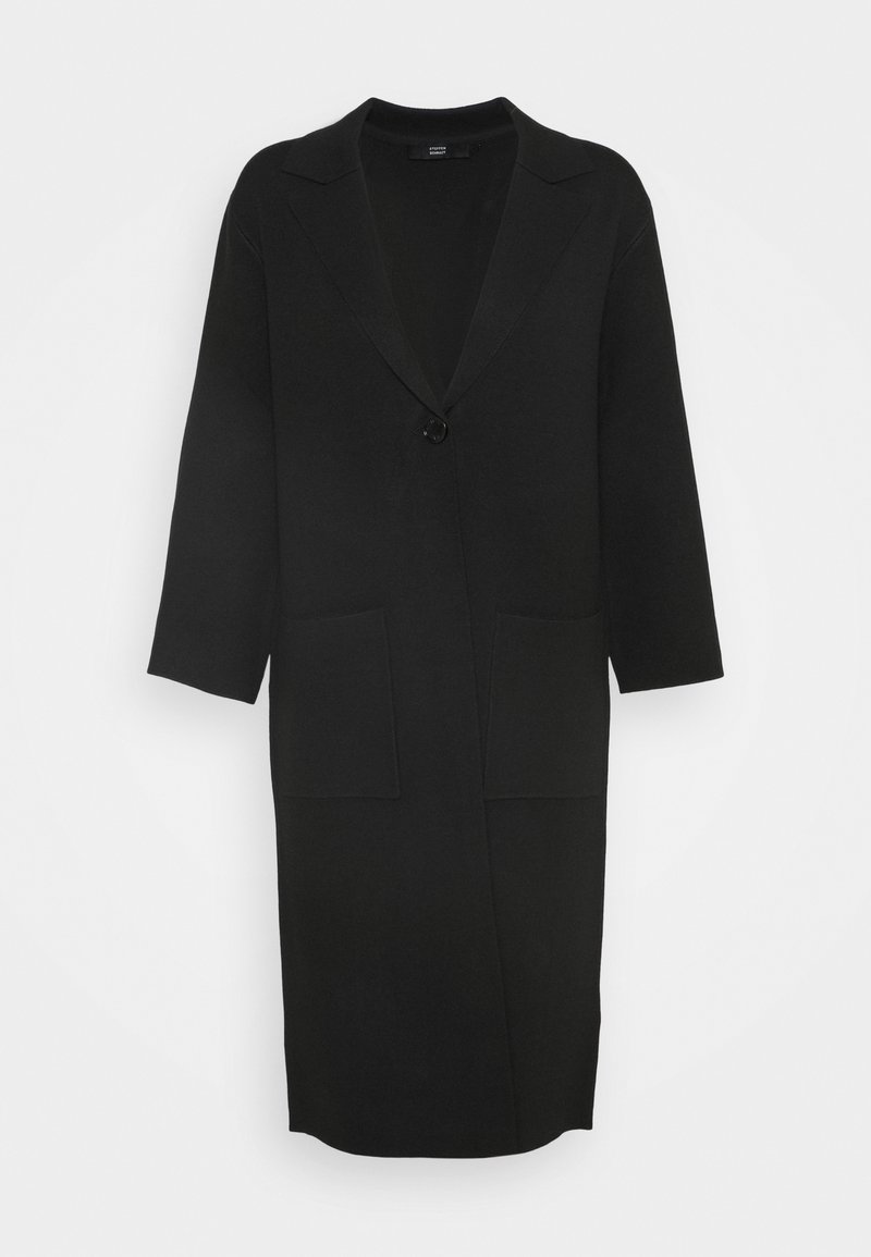 Cappotto lungo nero realizzato in un materiale morbido, con revers a punta, chiusura con un bottone e due tasche anteriori.