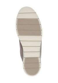 Sneakeri talla tekstuuriga kummist pinnaga, millel on kõverad ja sirged sooned. Värv on beige, mille servade ääres on heledat kreemi tooni aktsente.
