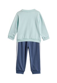 Sudadera azul clara con cuello redondo y puños de canalé, combinada con pantalones tipo jogger azul oscuro que presentan rayas blancas a los lados.