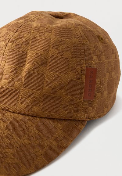 Καφέ υφασμάτινο καπέλο μπέιζμπολ με γεωμετρικό μοτίβο και μικρή δερμάτινη ετικέτα με την ένδειξη «SANDRO» στο πλάι.