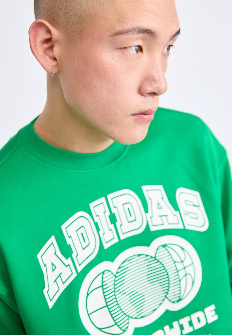 Groene sweatshirt van katoen, met grote witte grafische tekst en cirkelpatronen. Geribbelde halslijn en textiel met textuur.