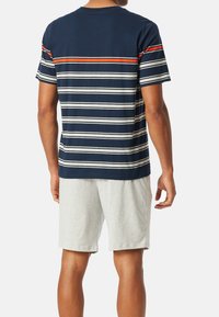 Camiseta de rayas marinas con rayas horizontales blancas y naranjas, combinada con pantalones cortos grises claros. Material de algodón, corte holgado, mangas cortas.