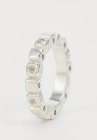 Sudraba gredzens ar maiņojošiem gludajiem kvadrātiem un teksturētām apaļām daļām, katra apaļā daļa papildināta ar nelielu caurspīdīgu dārgakmeni.