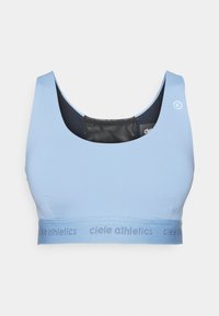 Svijetloplavi atletski grudnjak s širom trakom na kojoj je ispisan brend "ciele athletics". Glatka tekstura, izrezani dekolte i bez vidljivih kopčanja.