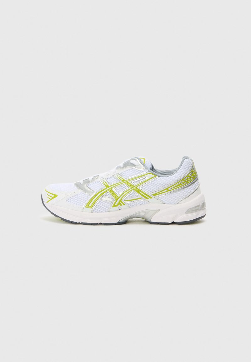 Shoe desportivo branco com parte superior em malha, realces cinzentos refletivos e detalhes amarelos nos painéis laterais e nos cordões. Sola de borracha incluída.