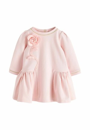 Zachte roze babyjurk met lange mouwen, met geplooide rokdelen en een 3D bloemapplicatie op de linkerborst, met subtiele gouden rand.