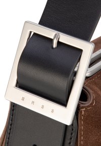 Cintura in pelle con fibbia quadrata in argento con marchio in rilievo. Cinturino nero attaccato a base in suede marrone, che mette in risalto il contrasto tra i materiali.