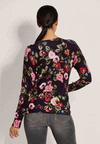 Blumiger Strickpullover mit einem dunklen Hintergrund und bunten Rosen- und Blattmustern. Langes Mieder und gerippter Saum runden das Design ab.