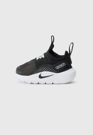 Baskets noires pour enfants de Nike avec un dessus en mesh respirant, une sangle élastique, une semelle blanche rembourrée et des accents de logo en blanc.