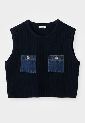 Navy ribbed ilmanhiha toppi, jossa on kaksi denim-patch taskua kultaisilla napeilla. Pyöreä pääntie ja lyhennetty muoto.