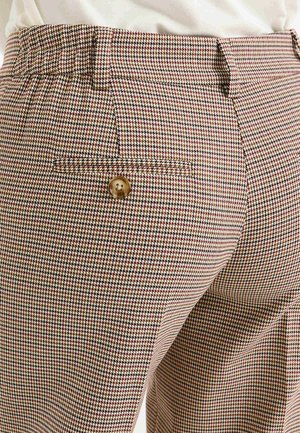 Pantalones de cuadros en beige, marrón y burdeos; cinturilla elástica; único bolsillo trasero con un detalle de botón dorado.