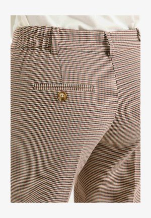 Pantalons à carreaux en beige, marron et bordeaux ; taille élastique ; poche arrière unique avec un détail de bouton doré.