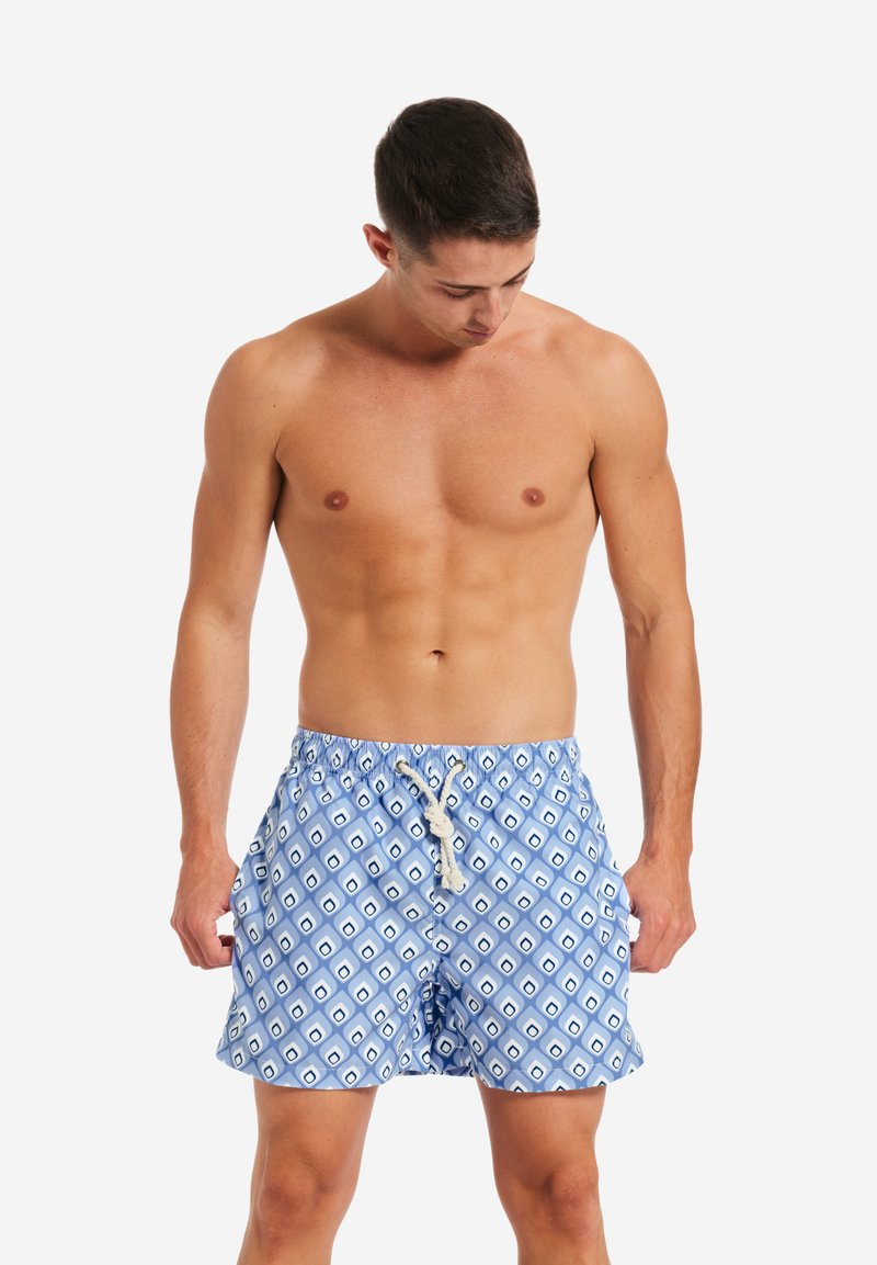 Costumi da bagno blu con motivo geometrico e accenti bianchi, dotati di vita elastica e chiusura con cordoncino. Tessuto leggero.