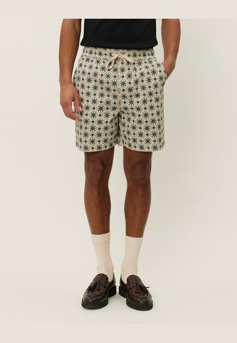 Bermudas de hombre con estampado en beige claro y diseños florales en verde, con cintura elástica y cordón, y bolsillos laterales.