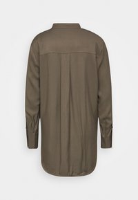 Camicia marrone a maniche lunghe con dettaglio back yoke, piega centrale, polsini con bottone e orlo arrotondato, mostrata piatta con visuale dal retro.