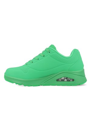 Zielony sportowy sneaker z sznurowadłami, wyściełanym kołnierzem, perforowanymi detalami i widoczną poduszką powietrzną w podeszwie środkowej na białym tle.
