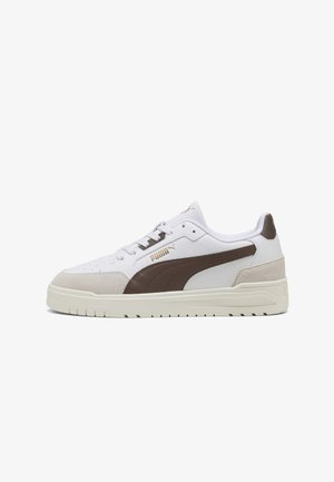 Białe sneakersy z brązowymi zamszowymi akcentami i gładkim skórzanym wykończeniem. Posiadają teksturowaną podeszwę oraz złote logo na boku. Klasyczny design.
