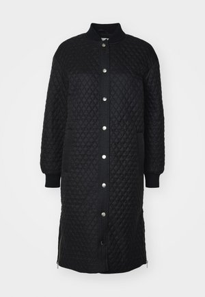 Čierny prešívaný dlhý kabát so zapínaním na zips, cvoky, rebrovanými manžetami, bočnými vreckami a textúrou s diamantovým vzorom.