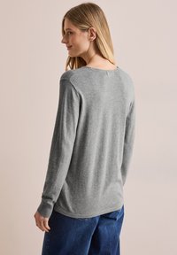 Grauer Langarmpullover aus weichem Material mit einem leicht lockeren Schnitt und gerippten Bündchen, ausgestattet mit einem runden Halsausschnitt und einer Nahtdetails am Rücken.