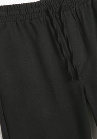 Schwarze Sweatpants mit elastischem Bund und Kordelzug, aus einem weichen Stoff gefertigt. Verfügt über eine saubere Nahtführung und eine glatte Textur.