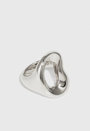 Silver ring with an organic, flowing design. Features a smooth, polished surface with an open oval shape and curving lines.