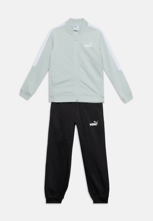 Veste zippée gris clair avec bandes blanches aux épaules et pantalon de survêtement noir, les deux avec logos Puma blancs.